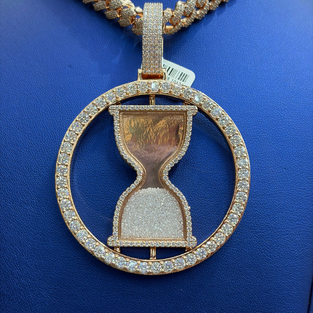 Rose gold hourglass pendant with diamonds on a blue background