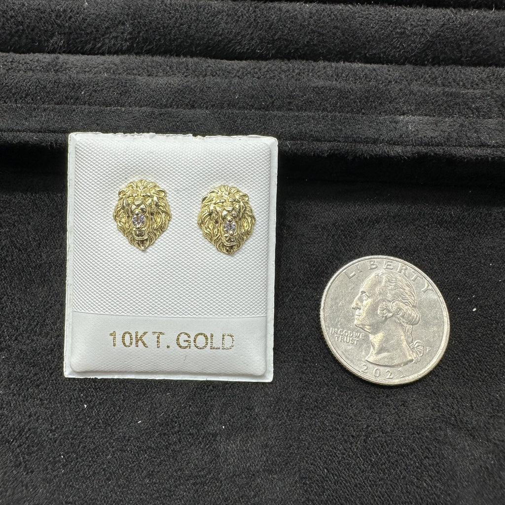Gold lion head earrings on a display card with a quarter for scale, all on a black background.