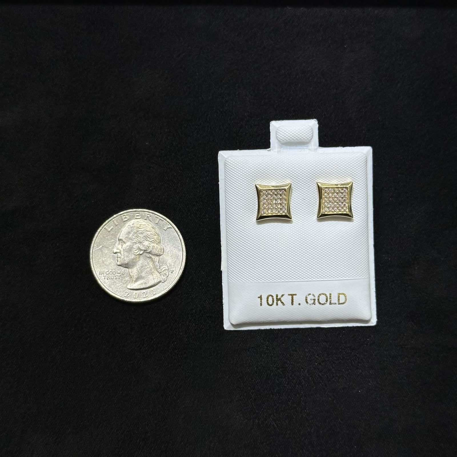 Gold cufflinks on a white card with '10Kt. Gold' text, next to a quarter for scale on a black background.