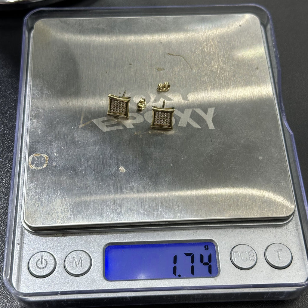 Gold earrings on a digital scale with a visible brand name.