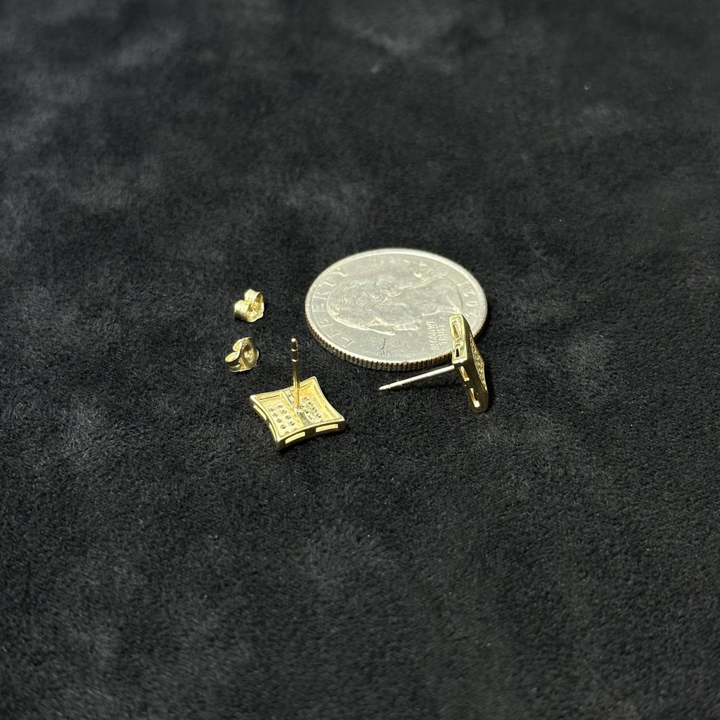 Gold earring components on a black background with a coin for scale.